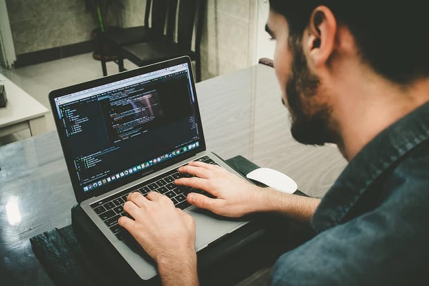 man coding on computer