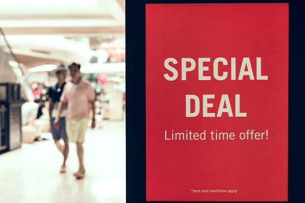 A special deal slide displaying beside a blurred image of people shopping in a mall